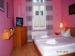 sypialnia z łóżkiem z różowymi ścianami i oknem w obiekcie Anna-App-01 w mieście Ahlbeck