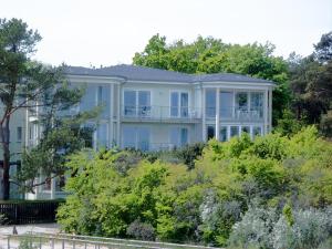 ein großes Haus auf einem Hügel mit Bäumen in der Unterkunft Strandoase App. 01 in Heringsdorf