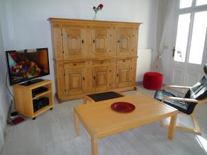 a living room with a wooden hutch and a table at Villa-Emmy-App-02 in Ahlbeck