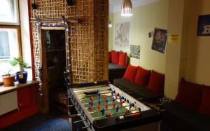 Habitación con mesa de futbolín y sofá en Naughty Squirrel Backpackers Hostel en Riga