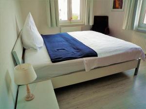 a bed with a blue blanket on it in a room at Villa-Emmy-App-02 in Ahlbeck
