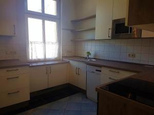 a kitchen with white cabinets and a window at Villa-Emmy-App-02 in Ahlbeck +4 photos