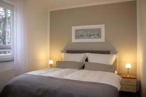 ヘリングスドルフにあるStrandoase-App-01のベッドルーム1室(大型ベッド1台、ランプ2つ付)