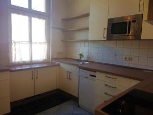 a kitchen with white cabinets and a microwave at Villa-Emmy-App-02 in Ahlbeck