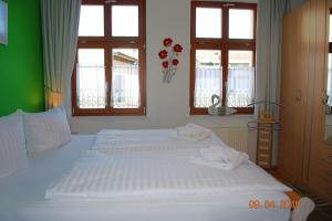 a bedroom with two beds with white sheets and windows at Bellevue-App-14 in Ahlbeck