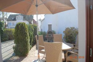 a table and chairs with an umbrella on a patio at Bellevue-App-14 in Ahlbeck