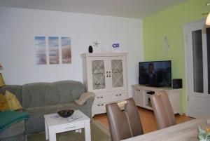 a living room with a couch and a tv at Bellevue-App-14 in Ahlbeck