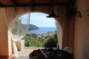 een kamer met een raam met uitzicht op de oceaan bij Villa Hermes Case Vacanza in Lipari