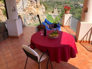 a red table with a basket of fruit on a balcony at Villa Hermes Case Vacanza in Lipari