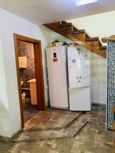 eine Küche mit zwei weißen Kühlschränken in einem Zimmer in der Unterkunft Diana's Holiday Home in Podu Dîmboviţei