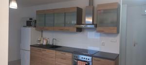 a kitchen with wooden cabinets and a white refrigerator at Apartmán CENTRAL, free parking in Banská Bystrica +3 photos
