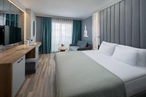 a hotel room with a large bed and a television at Siam Elegance Hotel & Spa in Belek