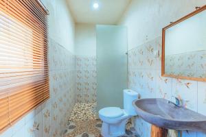 a bathroom with a sink and a toilet at Kabeh Jati Garden Villa & Restaurant in Nusa Penida