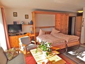 a bedroom with a bed and a table and a tv at Pra d'Sura 104 in Maloja