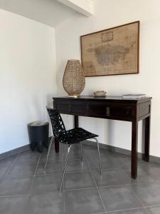 einen Schreibtisch mit einem Stuhl und einer Lampe in der Unterkunft Villa vue mer in Lumio