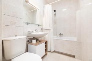 uma casa de banho branca com um WC e um lavatório em P&O Apartments Gamerskiego em Varsóvia