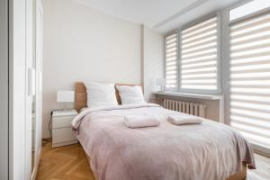 um quarto branco com uma cama grande e 2 almofadas em P&O Apartments Gamerskiego em Varsóvia