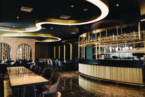 a restaurant with tables and chairs and a bar at Grand Central Premier Medan in Medan