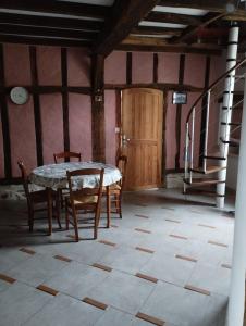 ein Esszimmer mit einem Tisch, Stühlen und einer Treppe in der Unterkunft Appartement, vue sur les Pyrénées in Pouillon