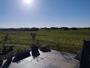 a patio with a view of a green field at Appartement, vue sur les Pyrénées in Pouillon