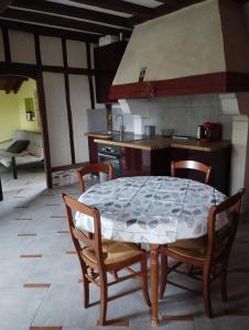 a kitchen with a table and chairs in a room at Appartement, vue sur les Pyrénées in Pouillon