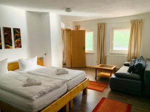 a bedroom with a large bed and a couch at Landhotel Cafe Prälank in Neustrelitz