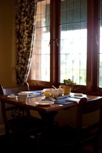 une table en bois avec de la vaisselle devant une fenêtre dans l'établissement Ridgeview Lodge, à Durban