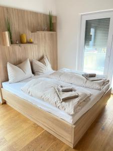 a large bed with white sheets and towels on it at Luxury Apartment Monte Carlo in Pörtschach am Wörthersee