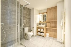 uma casa de banho com um WC e uma cabina de duche em vidro. em Aparthotel Adagio Access Saint Nazaire em Saint-Nazaire