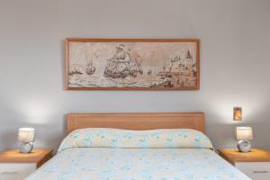 een schilderij boven een bed met twee nachtkastjes bij Appartamento in Villa Marlory in Monreale