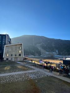 a group of people standing around a building with a beach at Divernoa Mountain Bjelašnica in Bjelašnica