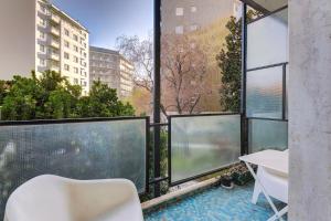 a balcony with large windows and a white table and chair at Design apartment in the design district of Milan in Milan