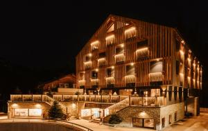 un edificio con luces encendidas por la noche en ALMMONTE PRÄCLARUM SUITES Design Hotel en Wagrain
