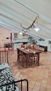 duża kuchnia i jadalnia ze stołem i krzesłami w obiekcie MANSARDA VITI - Sguardo su Frontone - w mieście Frontone