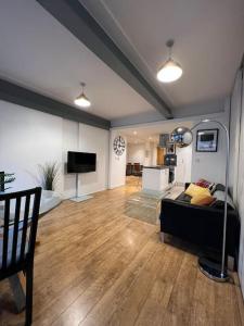 a living room with a couch and a flat screen tv at Modern Stratford Apartment with Parking in London
