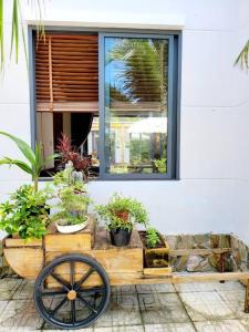 フーコックにあるSakura Mura Retreat and Wellnessの木製のカートに鉢植えの窓