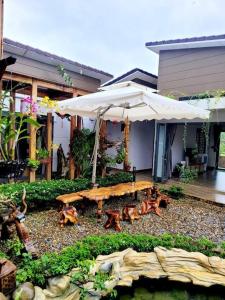 un patio con mesa y sombrilla en Sakura Mura Retreat and Wellness, en Phu Quoc