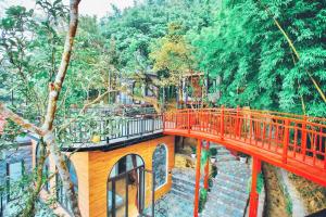 a red bridge in the middle of a forest at Thanh Tu Homestay - Venuestay in Vĩnh Phúc