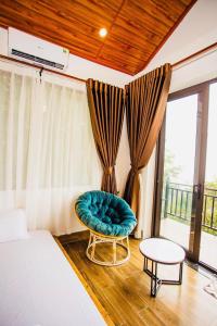 a bedroom with a bed and a chair and a window at Thanh Tu Homestay - Venuestay in Vĩnh Phúc
