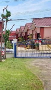 a fence in front of a building with a playground at Baan Aomsin in Chiang Khan