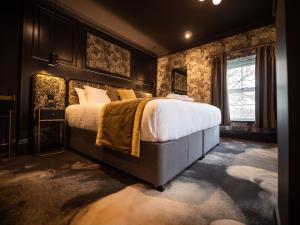 um quarto com uma cama grande e uma parede de pedra em The Funky Monk em Durham