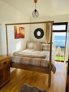 a bedroom with a canopy bed with a view of the ocean at Relaxing cottage with spectacular view, Sauna and Spa Pool in Kircubbin