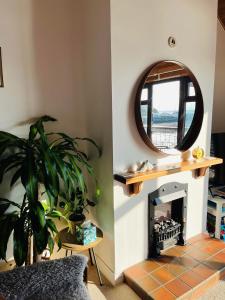 un soggiorno con camino e specchio di Relaxing cottage with spectacular view, Sauna and Spa Pool a Kircubbin