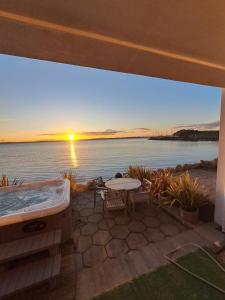 a patio with a hot tub and a table at Relaxing cottage with spectacular view, Sauna and Spa Pool in Kircubbin