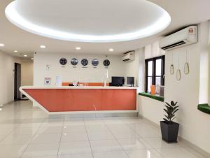 an office lobby with a red and white reception counter at 1 Orange Hotel Kuchai Lama KUALA LUMPUR in Kuala Lumpur