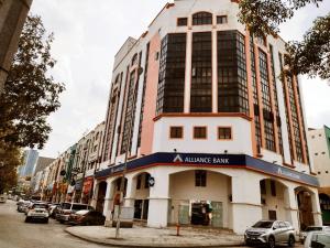 un edificio en una calle con coches aparcados delante en 1 Orange Hotel Kuchai Lama KUALA LUMPUR, en Kuala Lumpur