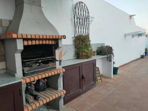 una cucina all'aperto con forno a legna su un patio di Apartamento en Puerto del Carmen a Puerto del Carmen
