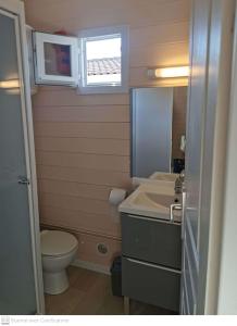 a small bathroom with a sink and a toilet at Camping Hameau Des Cannisses in Gruissan