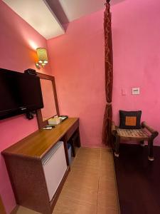 a room with a pink wall with a desk and a chair at Kenting Sea Cloudless Day Home in Kenting