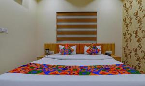een slaapkamer met een groot bed en een kleurrijke deken bij FabHotel Super 3 Premium in Varanasi